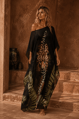 Woman wearing a black dress with a leopard print design in an indoor setting.