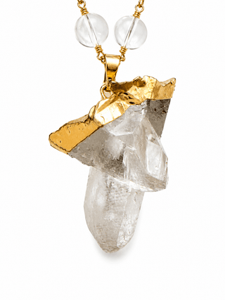 Close-up of natural raw quartz crystal pendant with gold setting