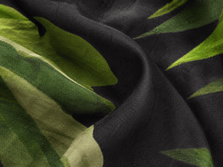 Close-up of black fabric with green leaf patterns