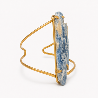 A gold wire-wrapped cuff bracelet featuring a large, vertically oriented natural blue lapis lazuli stone with white and gold veining, shown on a clean white background.