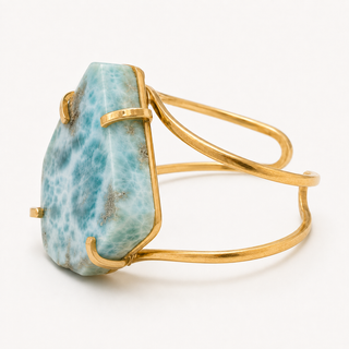 A gold wire wrap cuff ring featuring a large, irregular-shaped light blue and white marbled stone, shown on a clean white background.