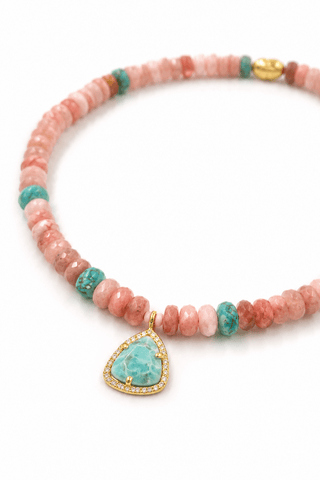 Necklace with pink beads and a turquoise pendant on a white background