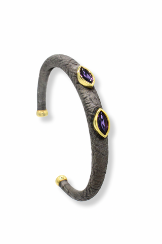 Gray textured bracelet with purple gemstones and gold accents on a white background