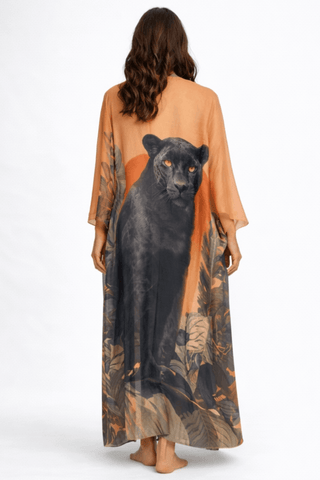 Woman wearing a long, sheer garment with a panther design on a white background